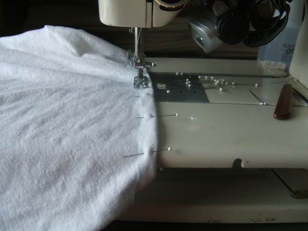 pulling pins out of casing as sewing proceeds