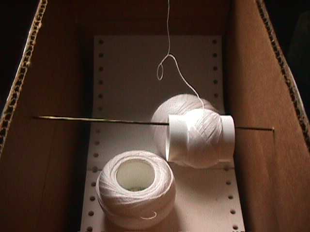 A thread dispenser made from a knitting needle and a box