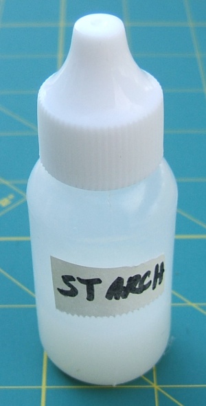 small bottle sitting 
                     on one-inch squares