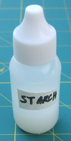 small bottle sitting 
                     on one-inch squares