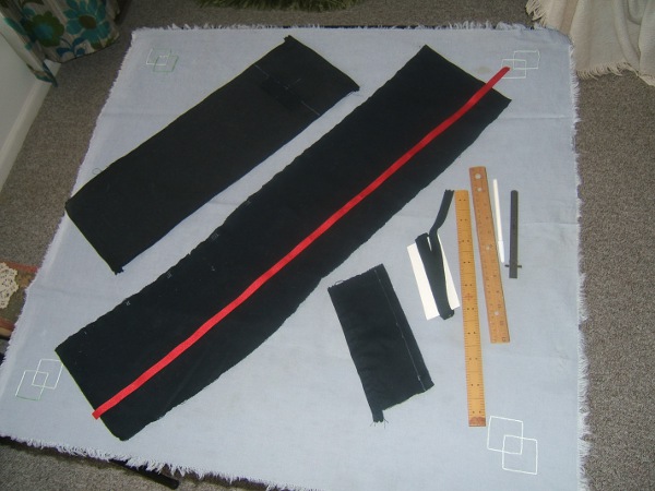wallet parts on card table:  duck outer casing, broadcloth strip 
                     to be torn into pockets, cards pocket, red twill 
                     tape, black twill tape